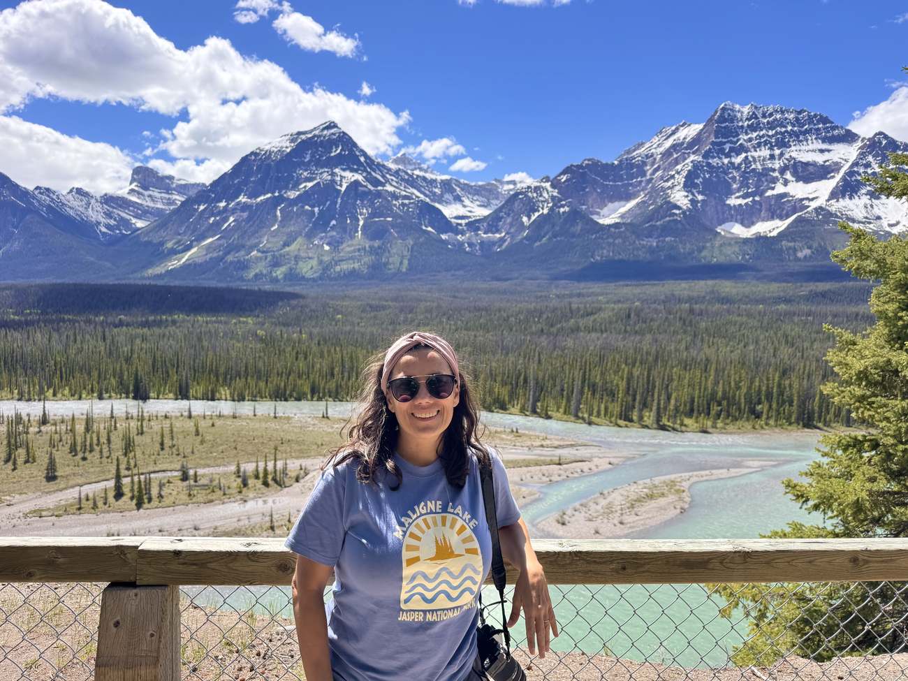 Patricia sonriendo ante las Rocosas y un río glaciar en Jasper, Canadá