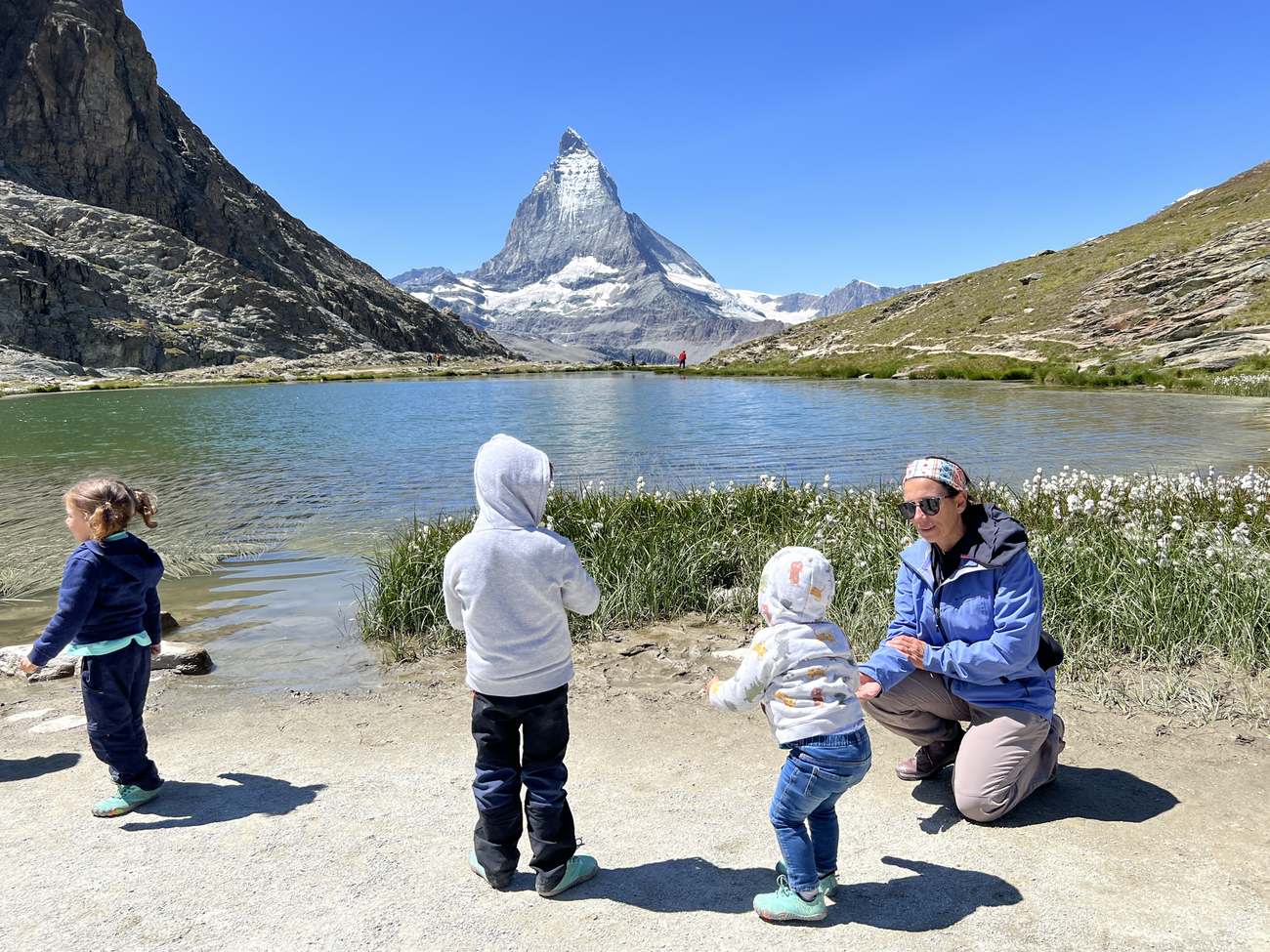 Una madre juega con sus tres peques ante el Cervino, junto al lago Riffelsee, en Zermatt, Suiza