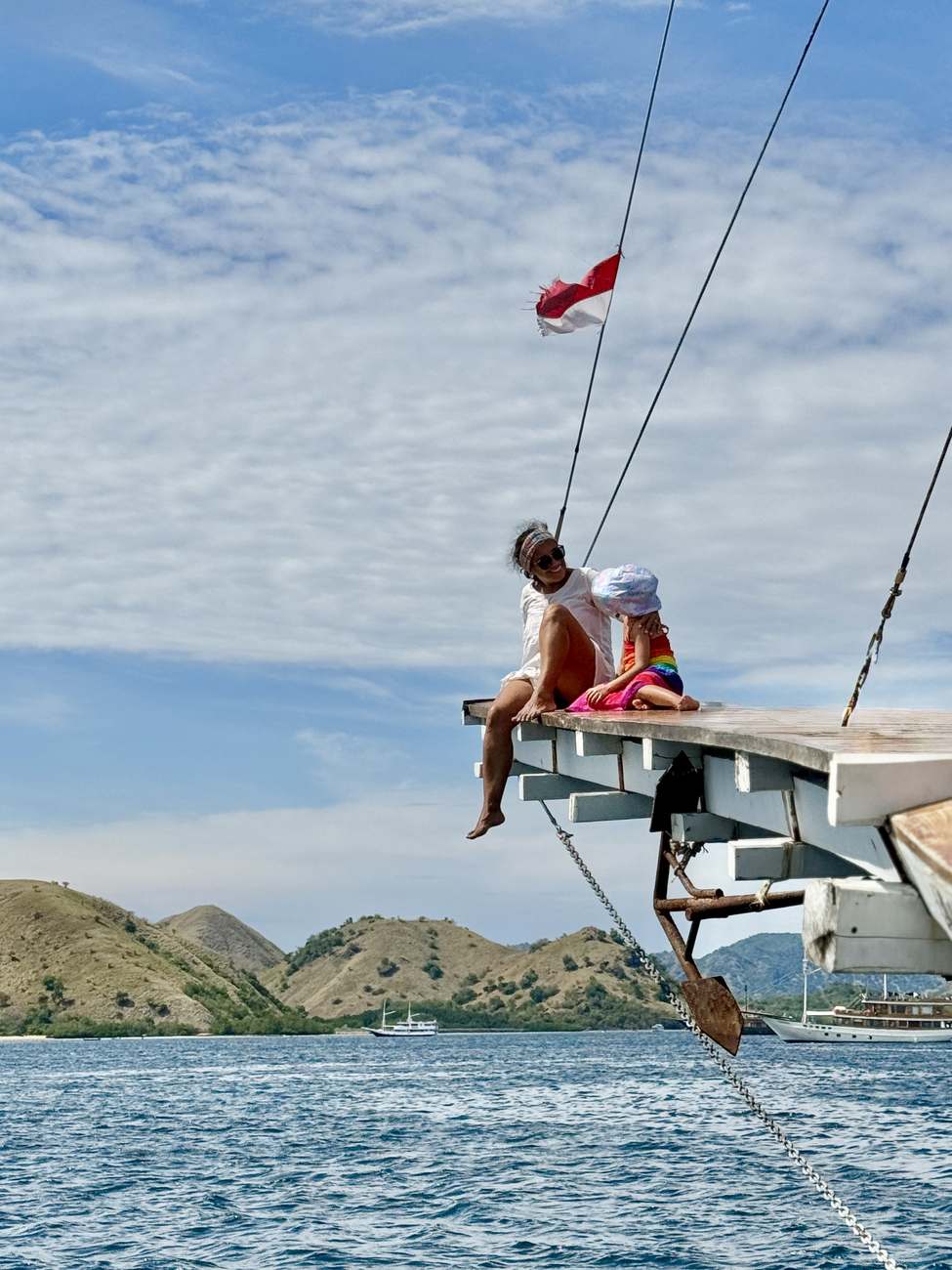 Patricia y su hija en el bauprés de un barco, en Komodo, Indonesia