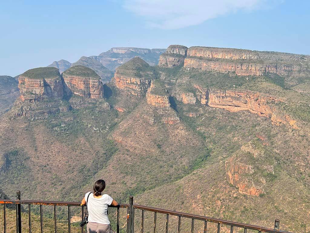 Los Three Rondavels del cañón del río Blyde vistos desde el mirador, con una persona de espaldas en la barandilla