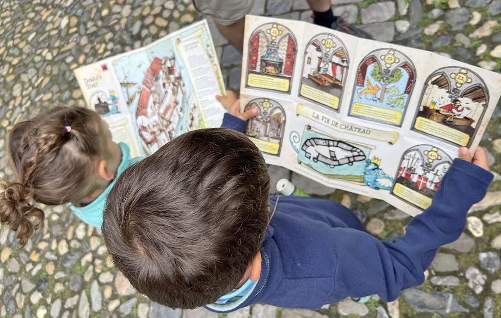 niños con el folleto infantil del castillo de chillon
