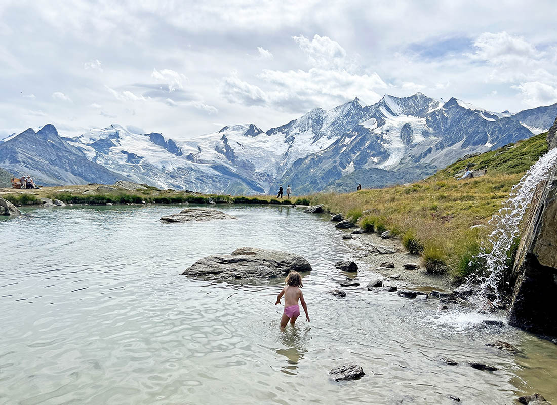 una niña bañándose en un lago en Kreuzboden, en Saas-Fee, Suiza