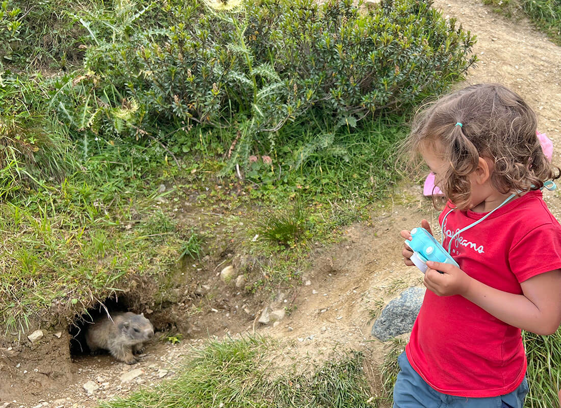 Una niña en Suiza junto a una marmota en Spielboden