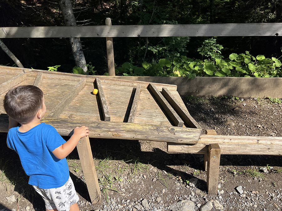 Niños haciendo rodar bolas de madera por un circuito Kugelbahn en la montaña, en Suiza