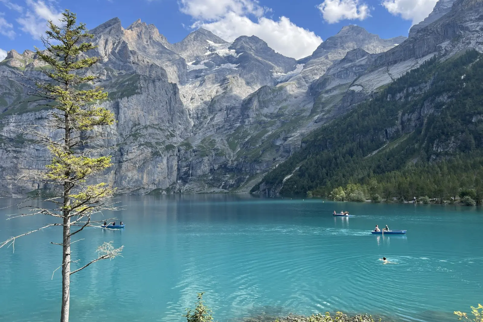 Barcas en el agua turquesa del Oeschinensee en un día de verano